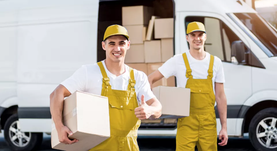Movers carrying boxes and holding thumbs up