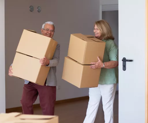 Old couple carrying boxes